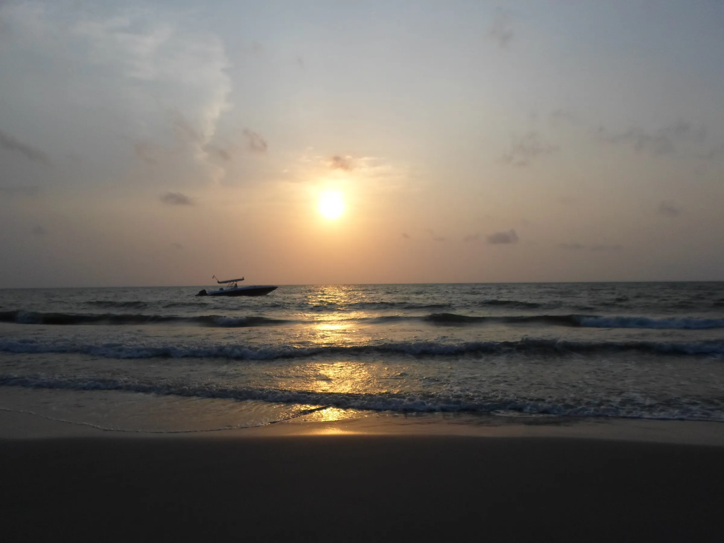 Atardecer en Necoclí: el sol sobre el golfo de Urabá y una lancha en el mar